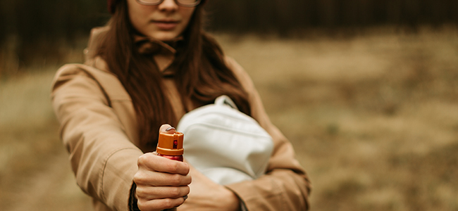 The concept of self-defense. Young girl holding a tear spray